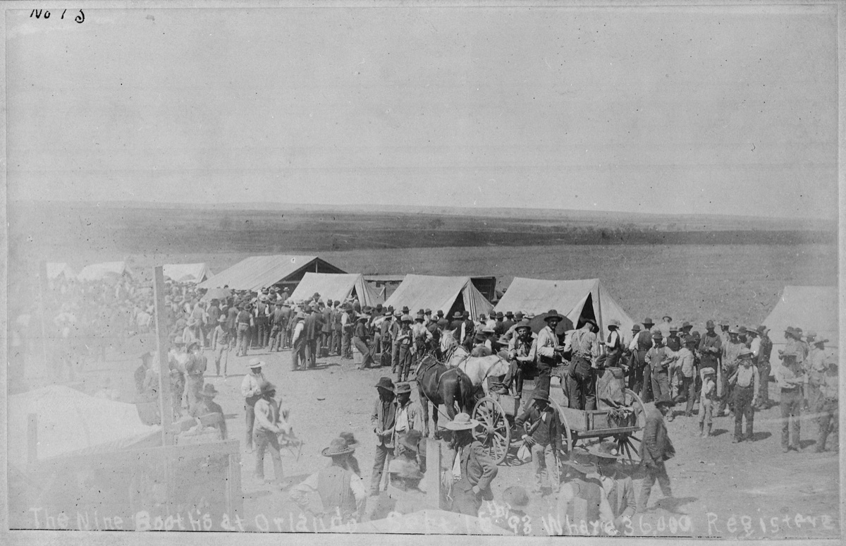 Tents and a long crowd of men and horses around wagons at the registration booths at Orlando, Oklahoma Territory, on 15 September 1893.
